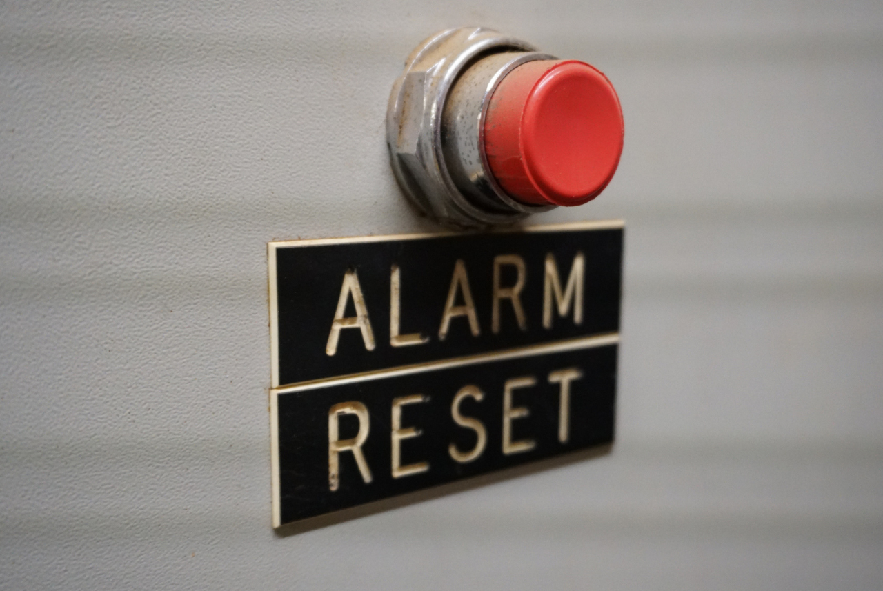 image of red button with alarm reset written underneath